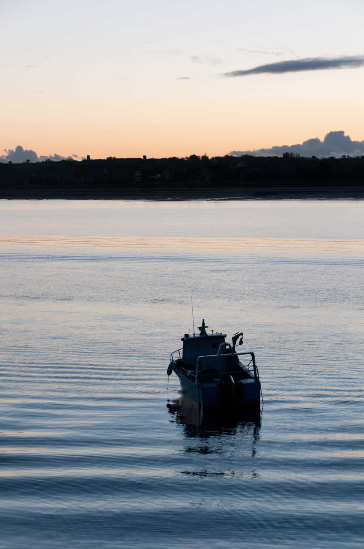 A little fishing boat at sunset off Gorey Pier, St. Martin