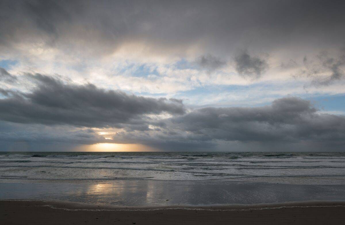 Sunset and clouds and waves on the beach at St. Ouen, Jersey