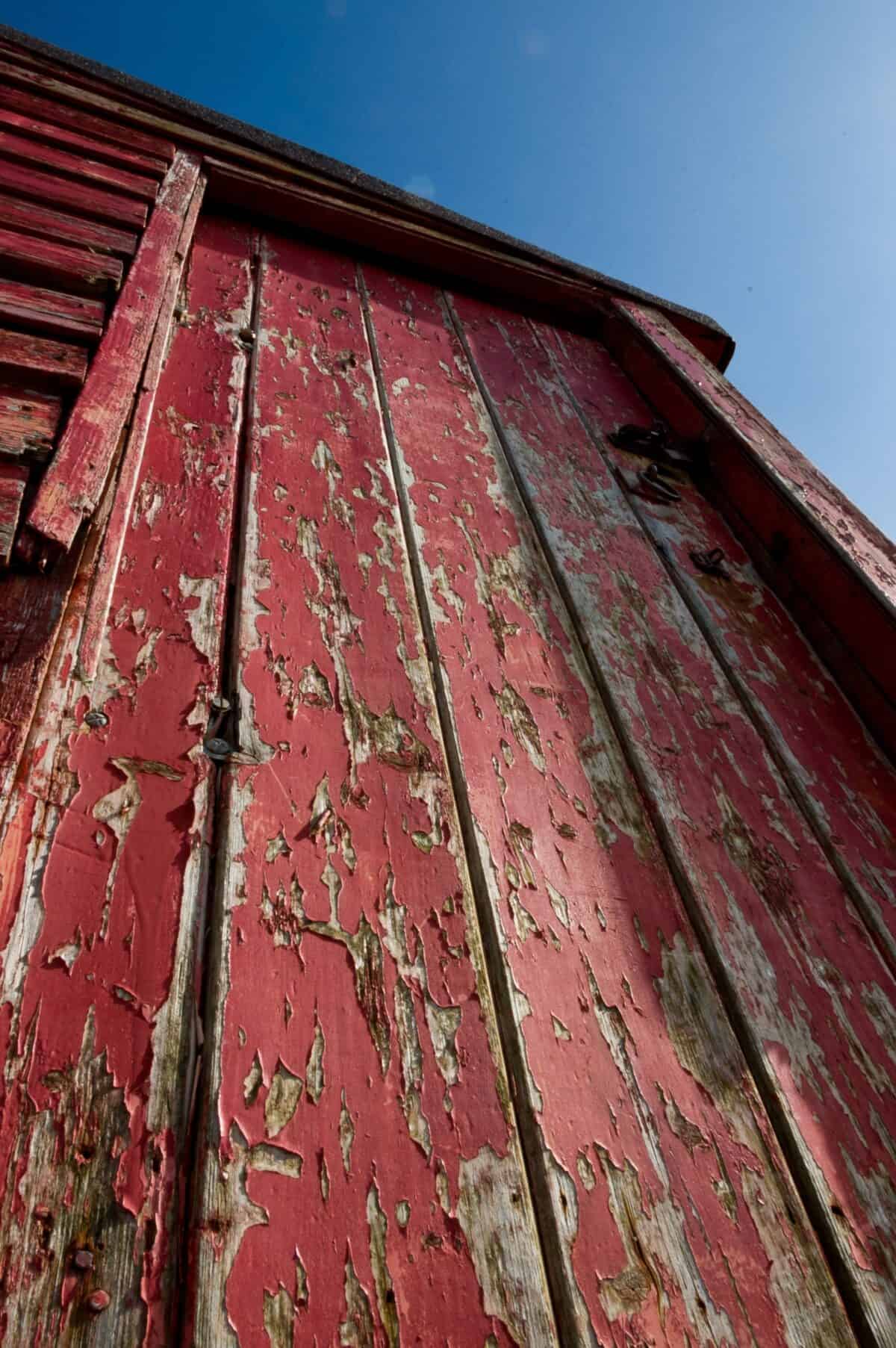 Flaking paint on old red fishing hut on Rozel Pier, Rozel Bay