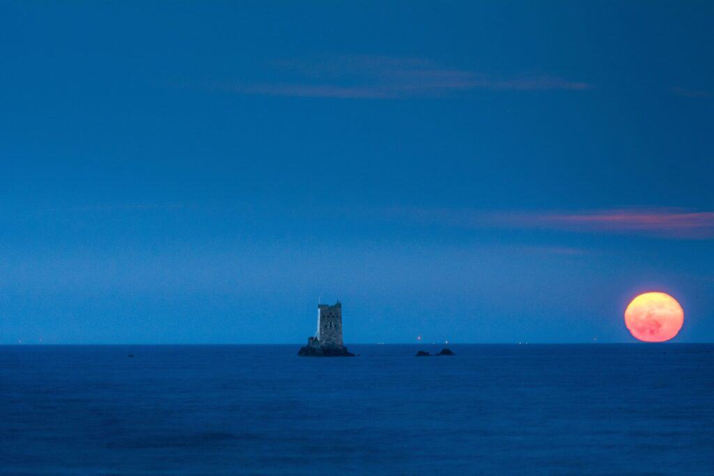 Full moon rising next to Seymour Tower, La Rocque, Grouville