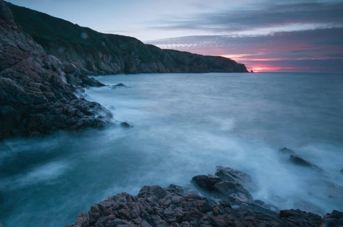 Sunset across Plémont Bay looking toward La Cotte à la Chèvre