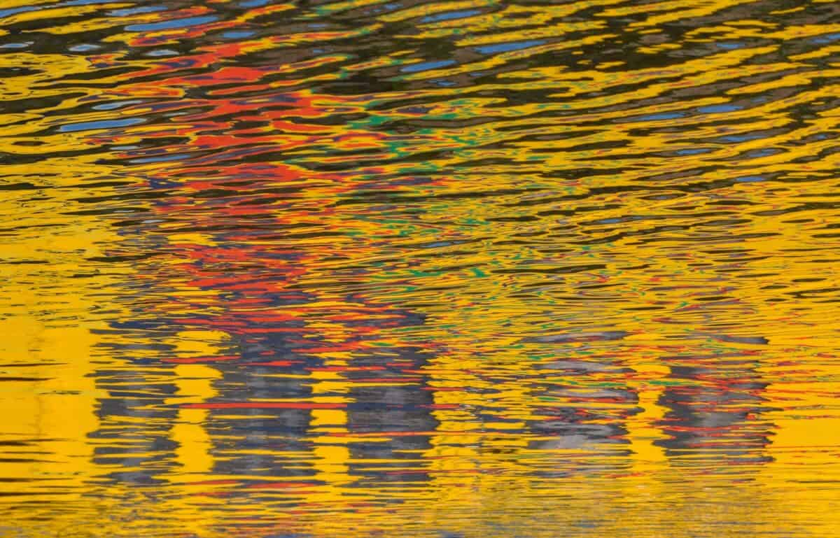 Windy ripples on The Steam Clock pond with a yellow reflection
