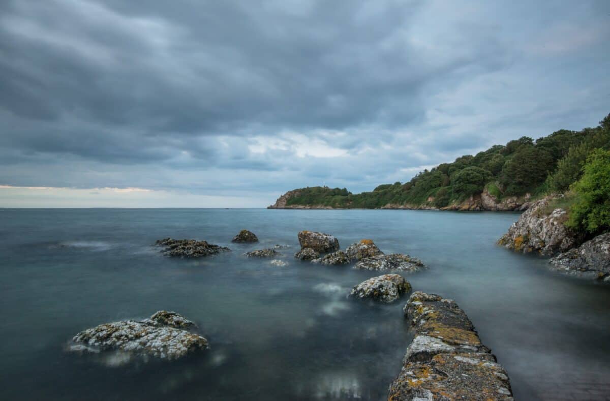 Sea, rocks and clouds at high tide at La Saie Harbour, Jersey