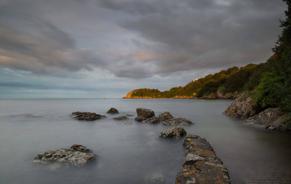 Sea, rocks and clouds at high tide at La Saie Harbour, Jersey