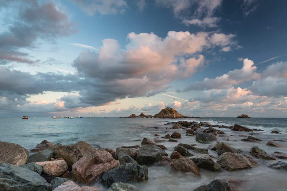Sea, rocks and clouds at sunset at high tide at Le Hocq Slipway