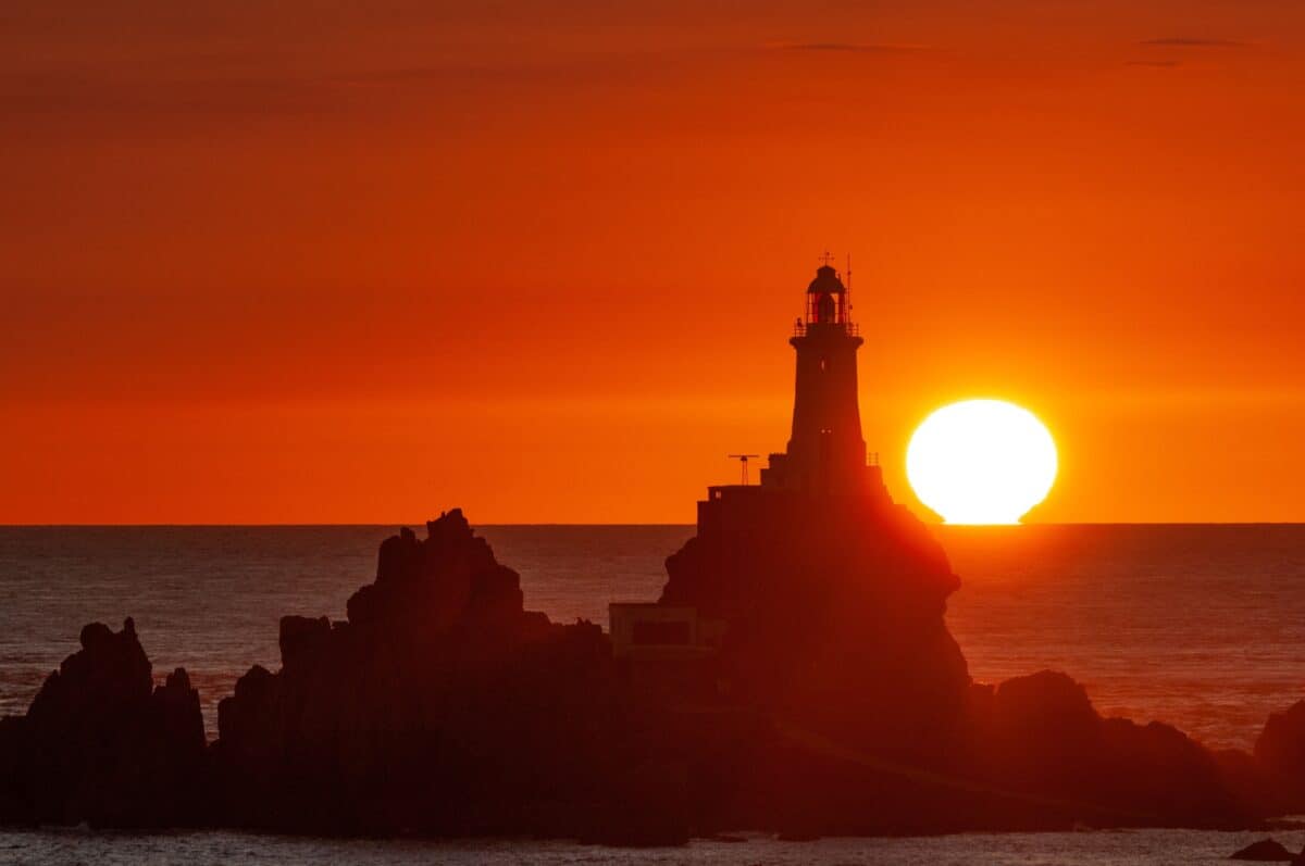 Vibrant sunset silhouette of Corbière Lighthouse, La Rosière