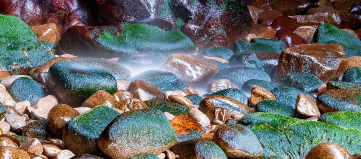 Small waterfall landing on rocks at Plémont Caves, Plémont Bay