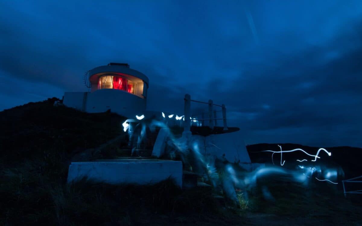 Sorel Point Lighthouse as fishermen walk past with torches on