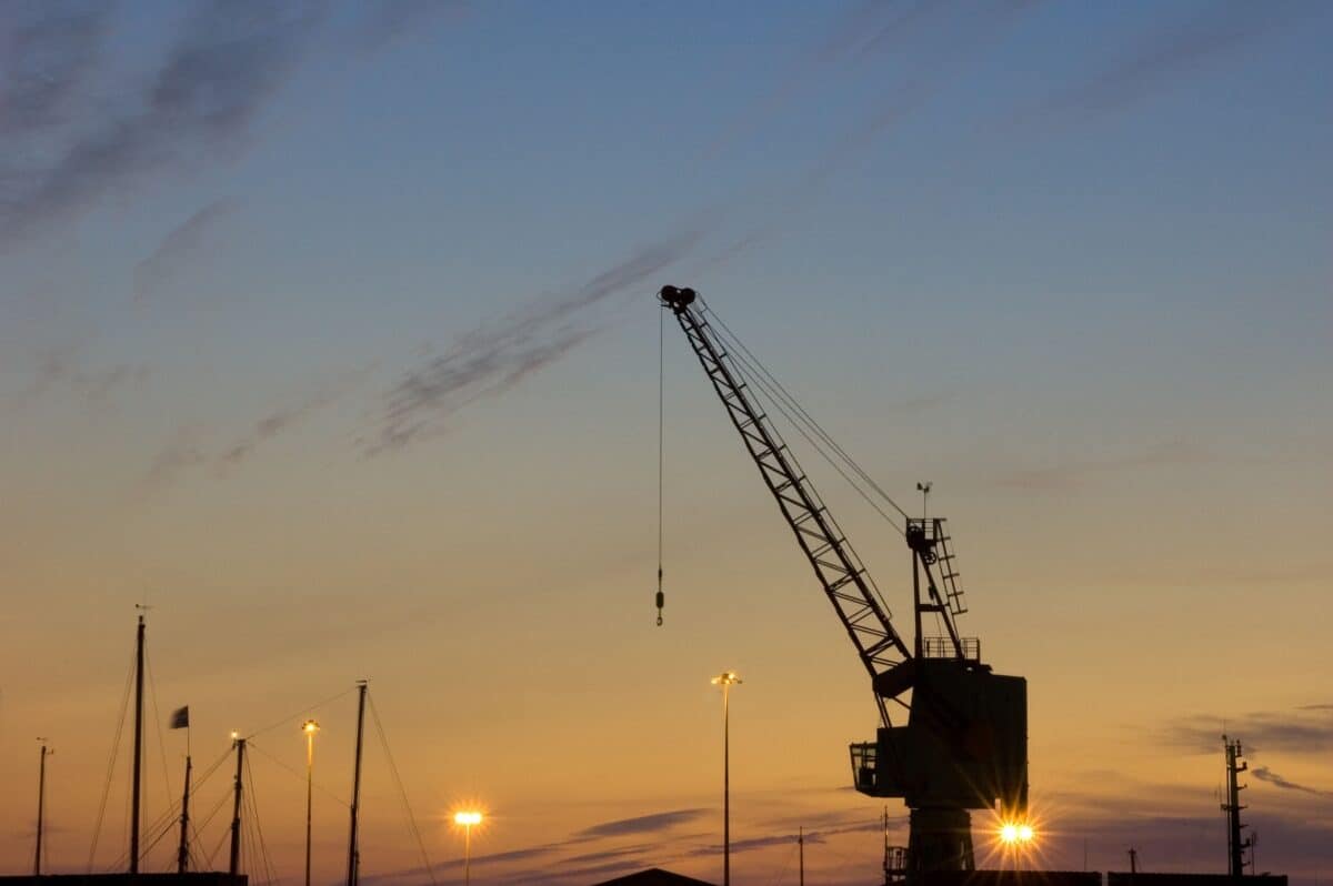 View of a crane on New North Quay at sunset from English Harbour