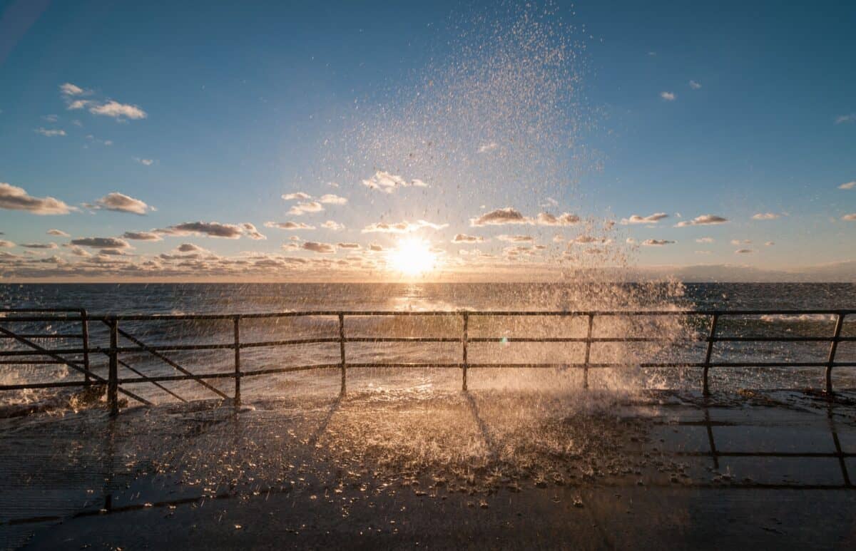 Waves bouncing off the sea wall at sunset, St. Ouen's Bay
