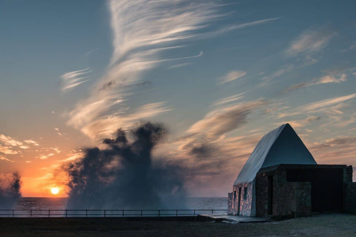 Waves splashing off the sea wall at sunset at The White House